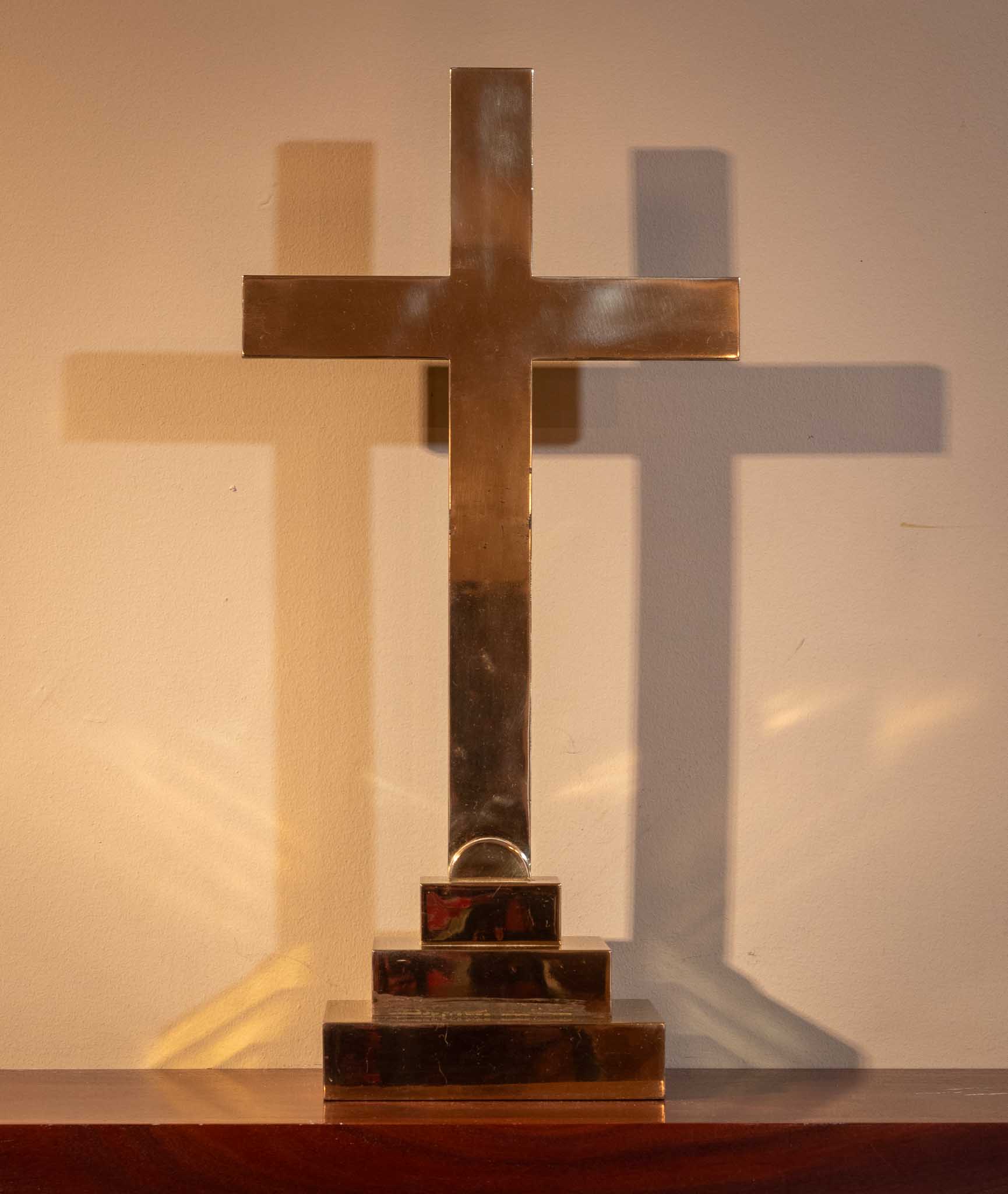 Cross with two shadows behind it.