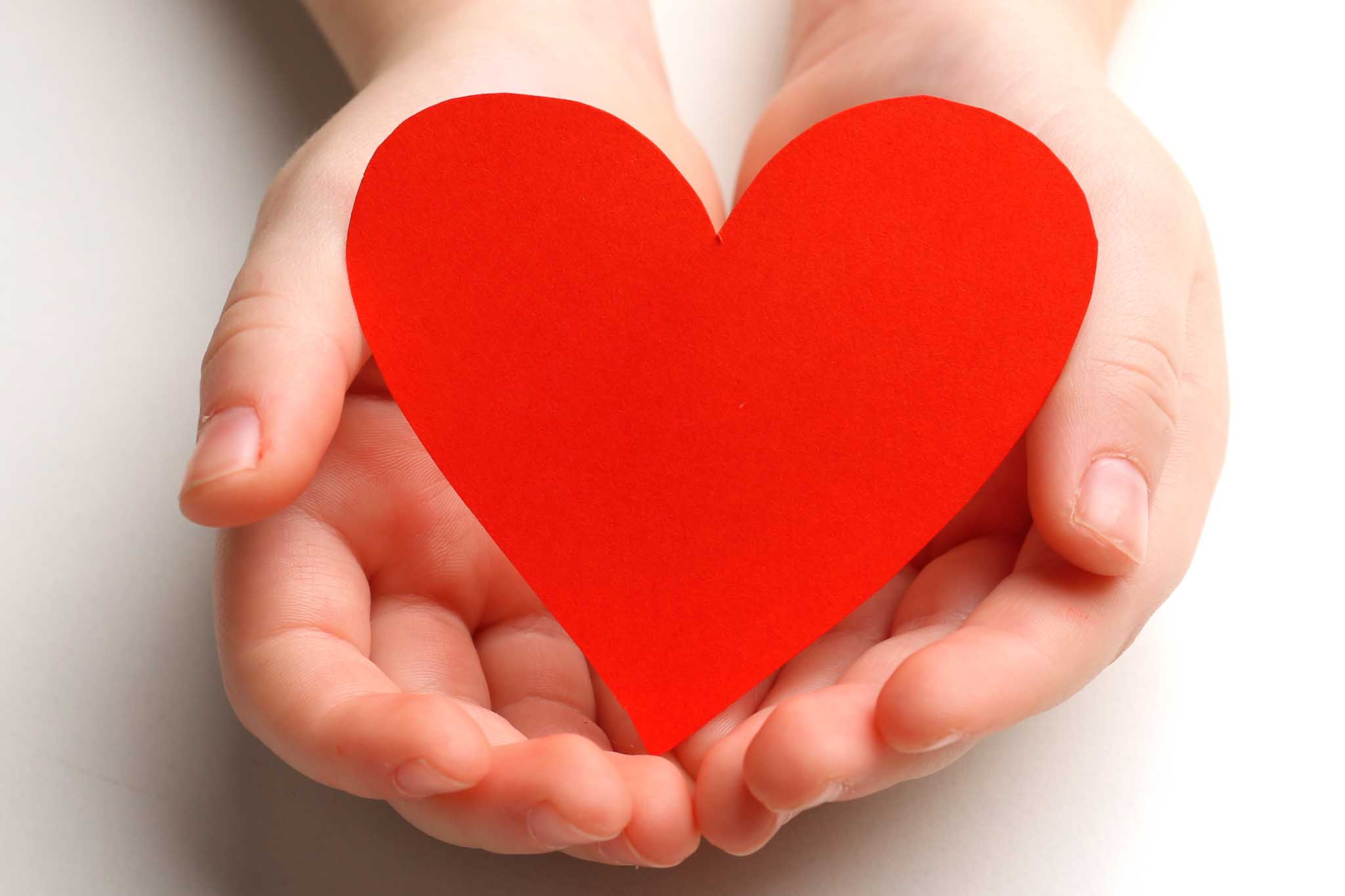Child holding a red heart.