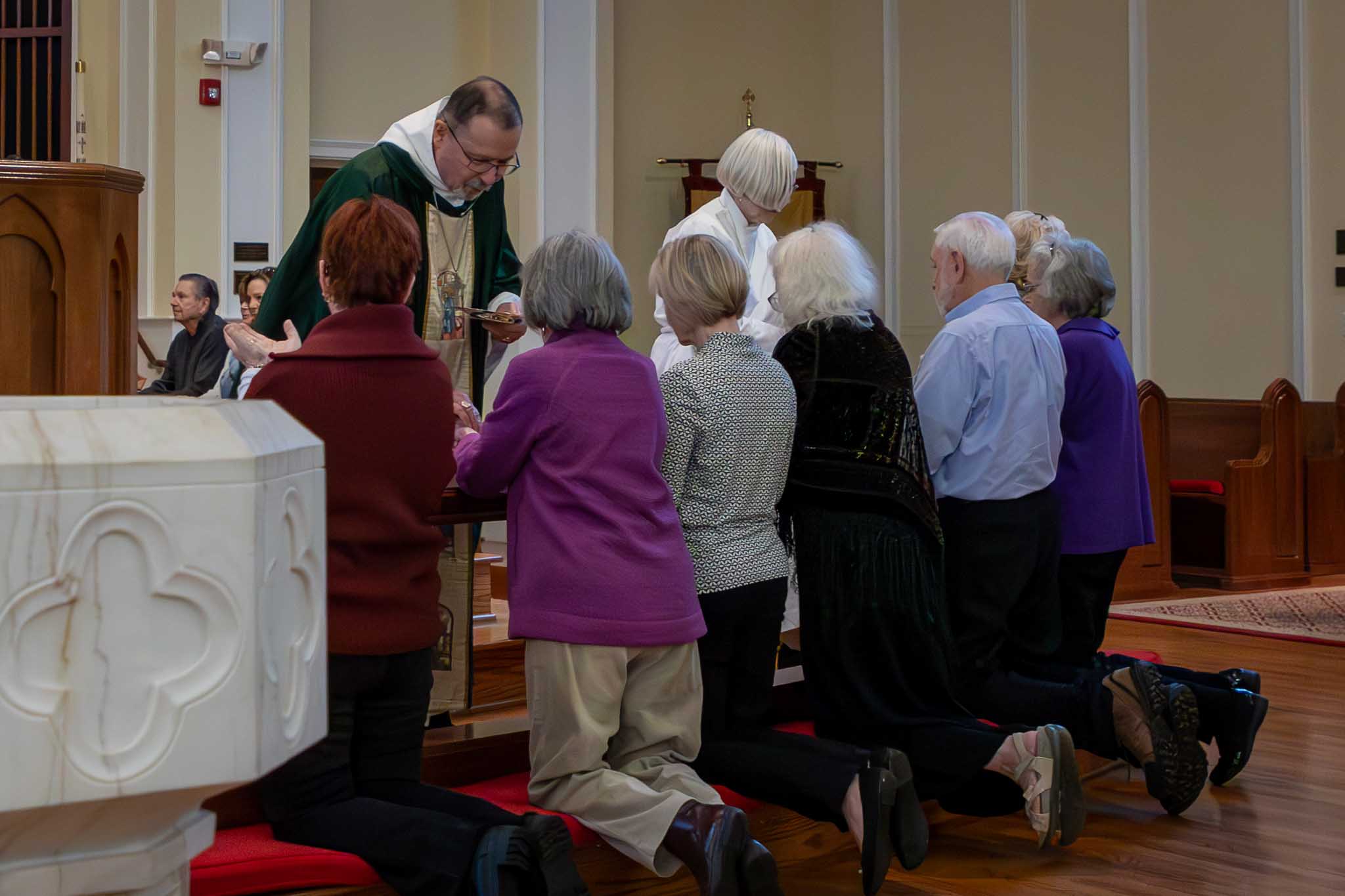 Minister giving communion to parishiohers.